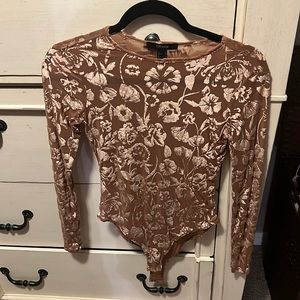 Gently used mauve/beige long sleeve bodysuit with velvet floral design.